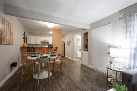 a living room and dining room with a table and chairs